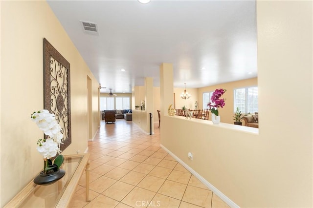 hall featuring visible vents, baseboards, an inviting chandelier, recessed lighting, and light tile patterned flooring