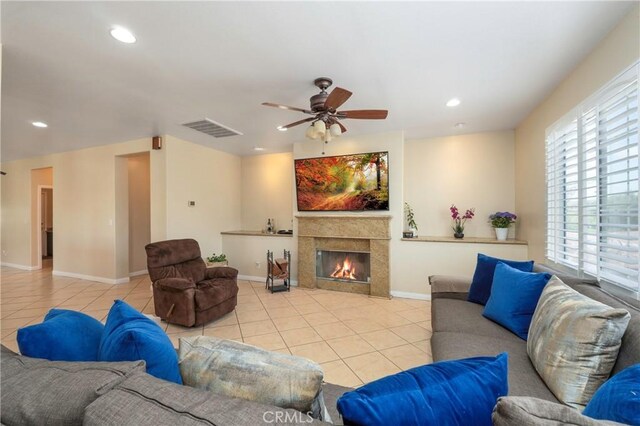 tiled living room featuring ceiling fan, a fireplace, recessed lighting, baseboards, and visible vents