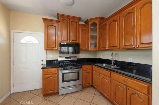 kitchen with gas range, black microwave, a sink, glass insert cabinets, and light tile patterned flooring