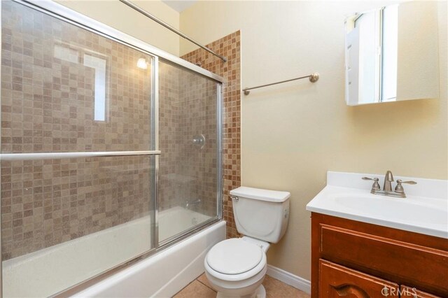 bathroom featuring vanity, bath / shower combo with glass door, and toilet