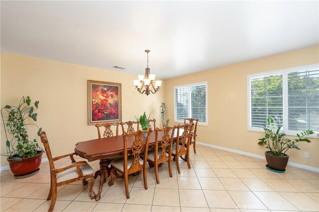 dining area with baseboards, a chandelier, light tile patterned floors, and visible vents