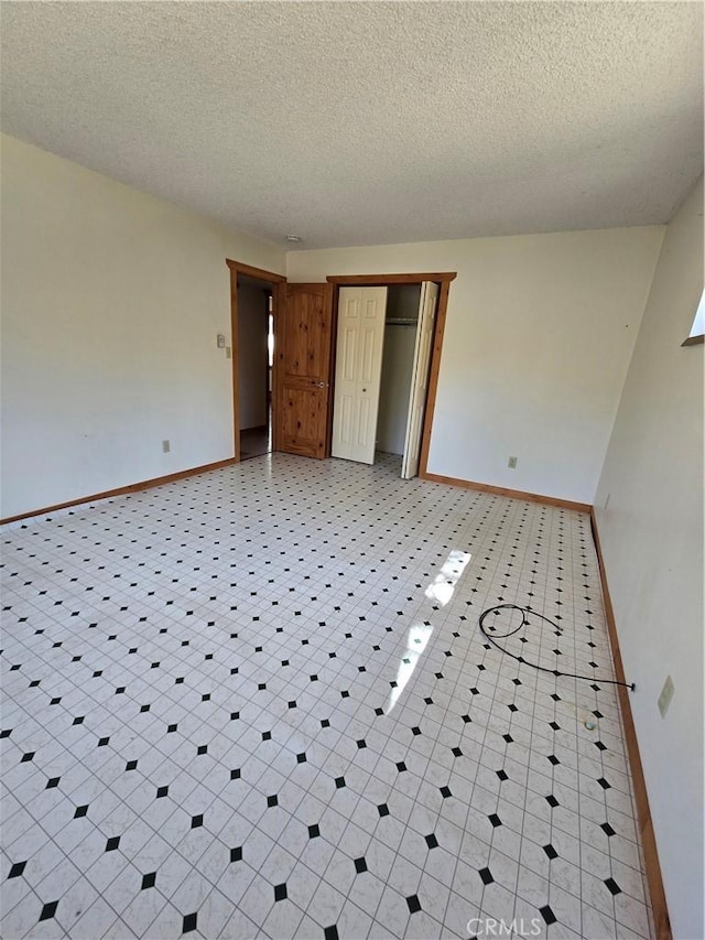 unfurnished bedroom featuring baseboards, a closet, and a textured ceiling