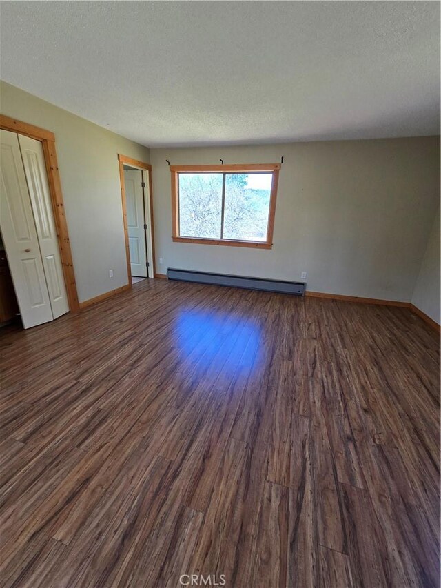 16631 Patricia Ave, Montague, CA 96064 - spare room with baseboards, a baseboard radiator, dark wood-style floors, and a textured ceiling