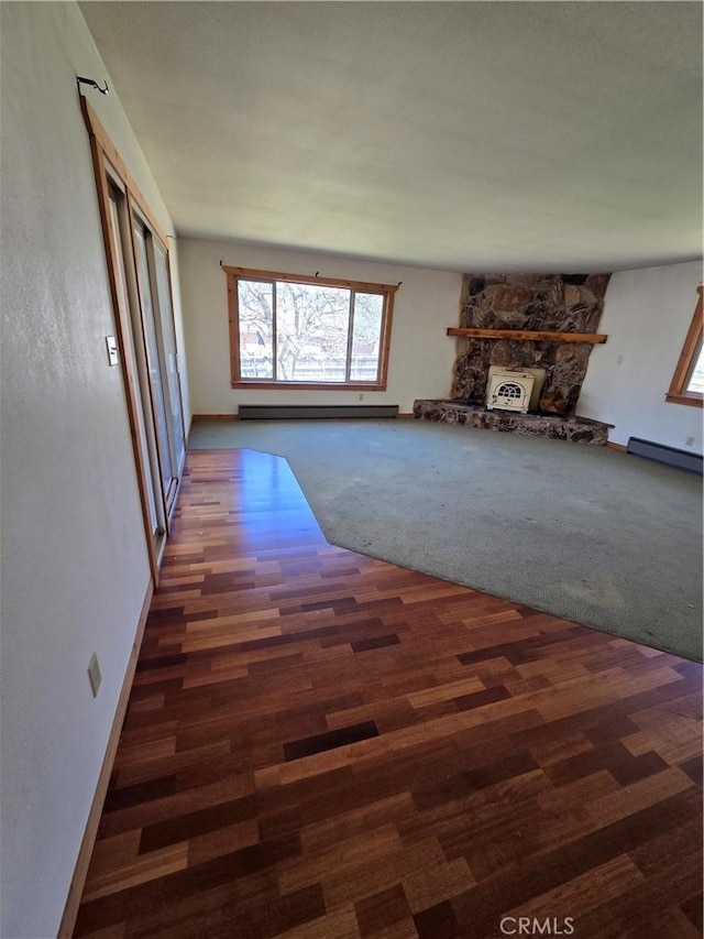 unfurnished living room featuring baseboards, a baseboard radiator, wood finished floors, and baseboard heating