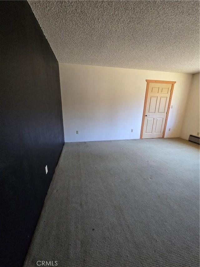 unfurnished room featuring carpet floors, a textured ceiling, and a baseboard heating unit