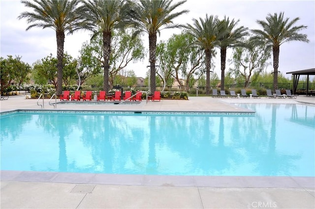 community pool featuring fence and a patio