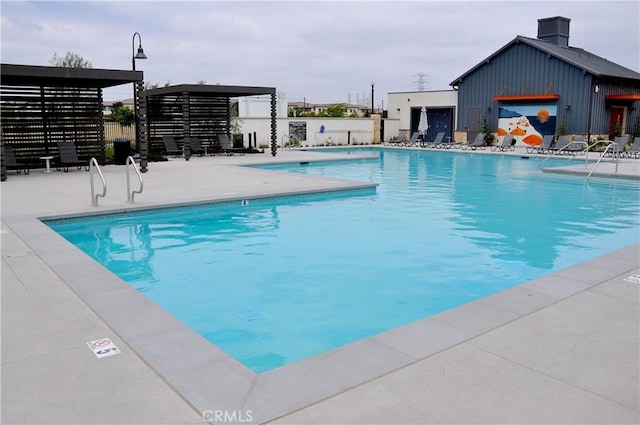 community pool with fence and a patio area