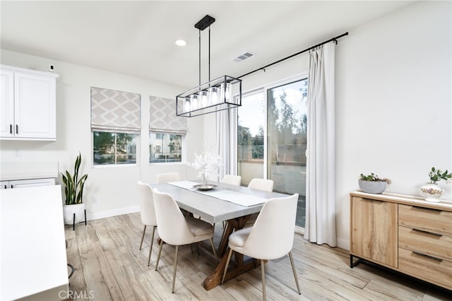 dining area featuring light wood finished floors, baseboards, recessed lighting, and a chandelier