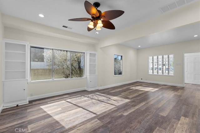 empty room featuring baseboards, a ceiling fan, wood finished floors, and visible vents