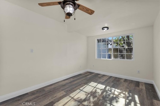 unfurnished room featuring dark wood-type flooring, a ceiling fan, and baseboards