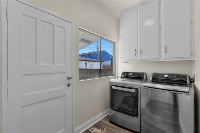 clothes washing area with washing machine and dryer, baseboards, wood finished floors, and cabinet space