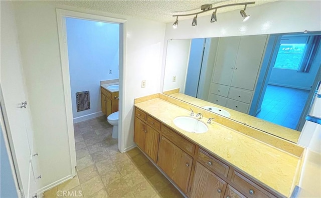 400 S Los Robles Ave Unit 306, Pasadena, CA 91101 - bathroom featuring a textured ceiling, toilet, vanity, and track lighting