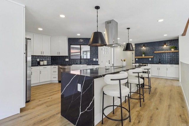 3612 Palomar Dr, Fallbrook, CA 92028 - kitchen with island range hood, decorative backsplash, white cabinetry, a kitchen bar, and recessed lighting