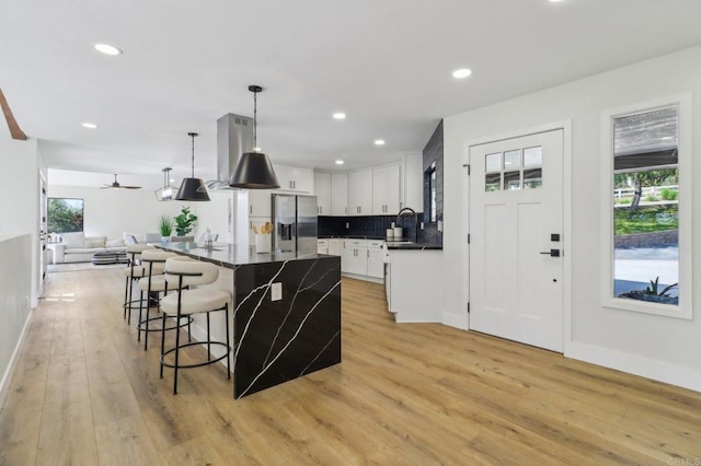 3612 Palomar Dr, Fallbrook, CA 92028 - kitchen featuring open floor plan, stainless steel fridge with ice dispenser, light wood-style floors, a breakfast bar, and dark countertops