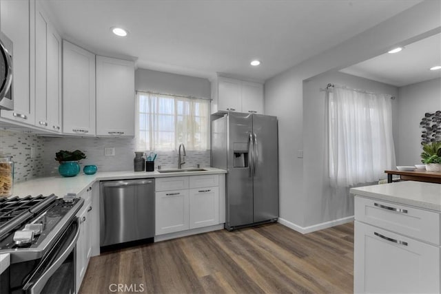4612 W 161st St, Lawndale, CA 90260 - kitchen featuring stainless steel appliances, a sink, dark wood-type flooring, light countertops, and decorative backsplash