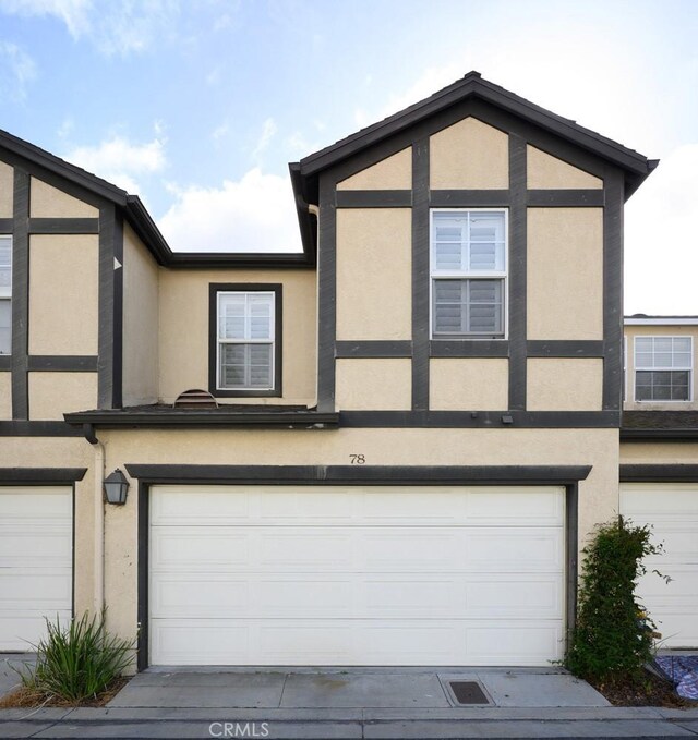 townhome / multi-family property featuring a garage, concrete driveway, and stucco siding