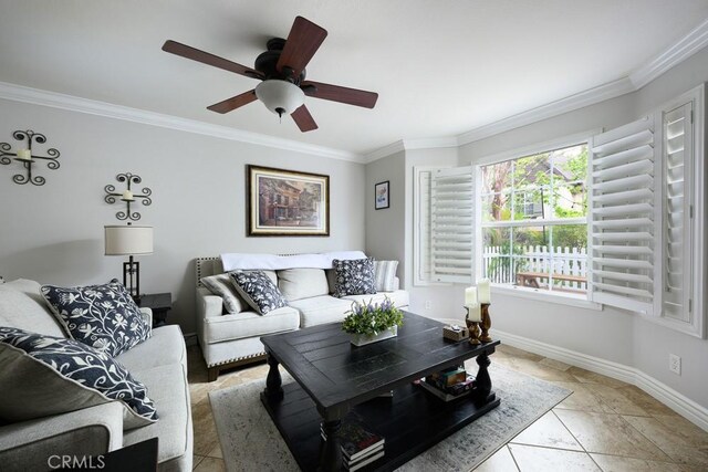 living area featuring light tile patterned floors, a ceiling fan, baseboards, and ornamental molding