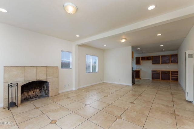 unfurnished living room featuring recessed lighting, a heating unit, light tile patterned floors, and a tile fireplace