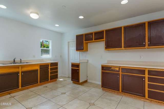 kitchen with light tile patterned flooring, a sink, light countertops, recessed lighting, and baseboards