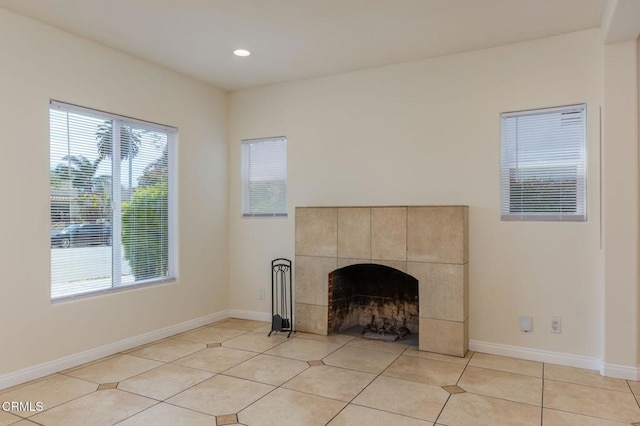 unfurnished living room with a healthy amount of sunlight, baseboards, and a fireplace