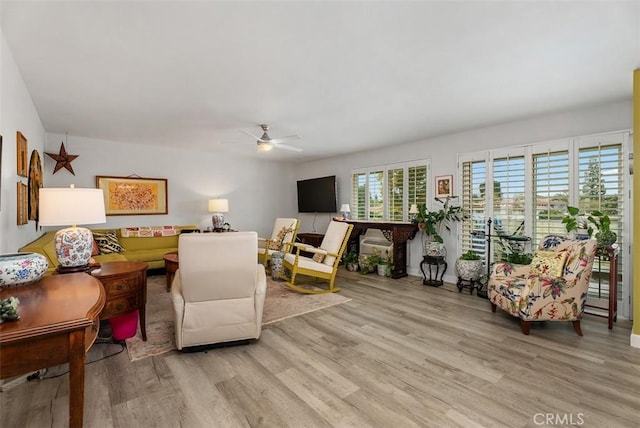 living room featuring a ceiling fan and light wood finished floors