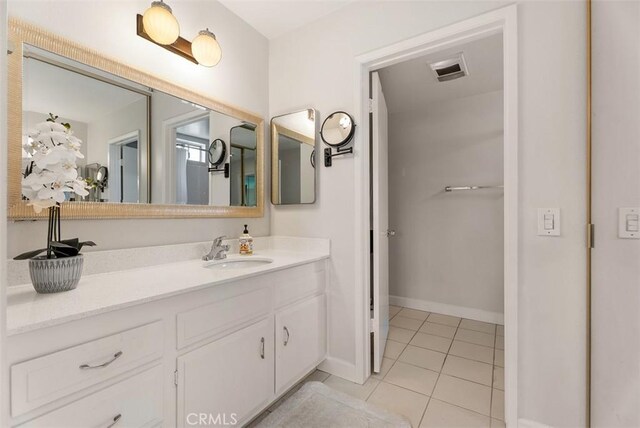bathroom with baseboards, visible vents, tile patterned floors, and vanity