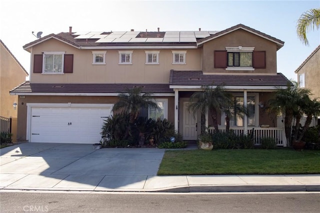 traditional home featuring roof mounted solar panels, covered porch, a front lawn, and a garage