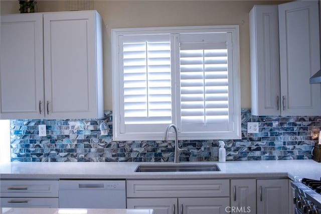 kitchen with decorative backsplash, white dishwasher, a sink, light countertops, and white cabinetry