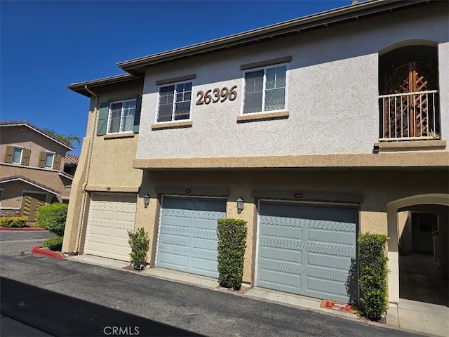 view of property with an attached garage and stucco siding