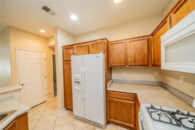 26396 Arboretum Way Unit 2906, Murrieta, CA 92563 - kitchen with white appliances, brown cabinetry, light countertops, recessed lighting, and light tile patterned floors