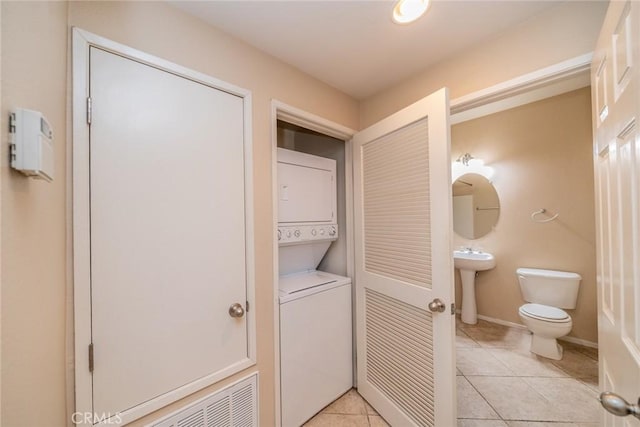 26396 Arboretum Way Unit 2906, Murrieta, CA 92563 - half bath featuring stacked washer and clothes dryer, toilet, tile patterned flooring, a sink, and baseboards