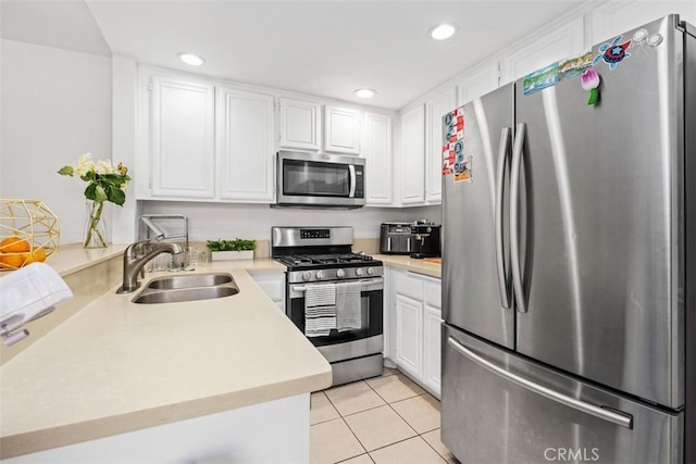 kitchen with light countertops, light tile patterned floors, stainless steel appliances, and white cabinetry