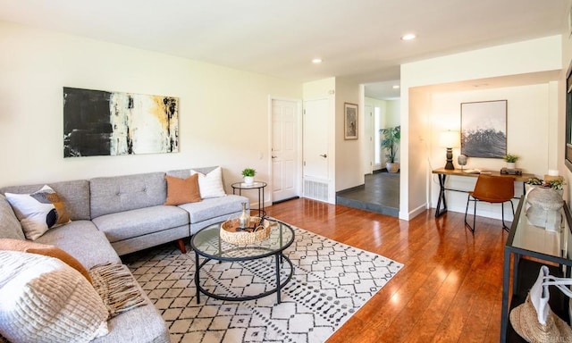 living room with wood-type flooring, recessed lighting, and baseboards