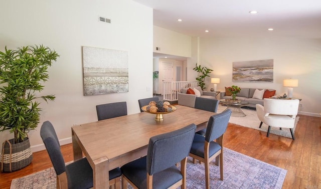 dining room with wood finished floors, baseboards, recessed lighting, and high vaulted ceiling