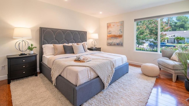 bedroom with wood finished floors, baseboards, and recessed lighting