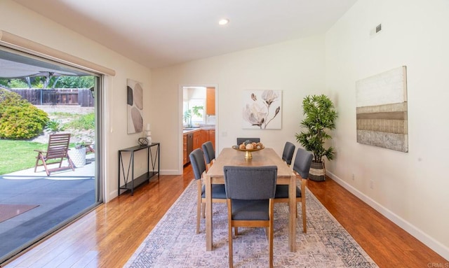 dining area with plenty of natural light, light wood-type flooring, baseboards, recessed lighting, and vaulted ceiling