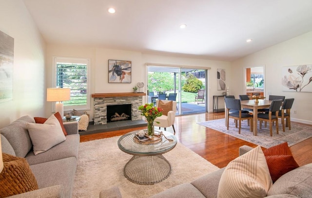 living area featuring wood finished floors, recessed lighting, lofted ceiling, and a fireplace