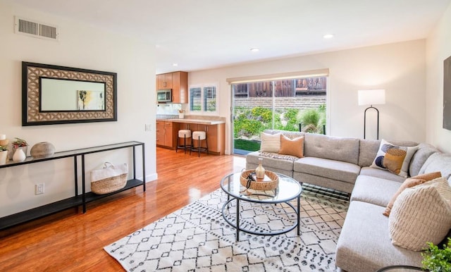 living area with light wood-style flooring and recessed lighting
