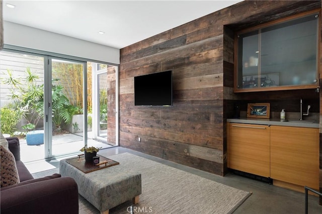 living area with recessed lighting, wood walls, and concrete floors