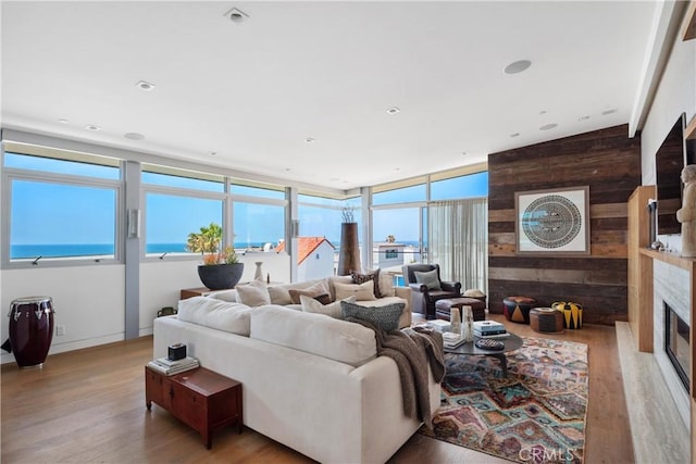 living room featuring wooden walls, a fireplace, and wood finished floors