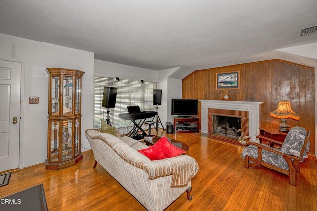 1404 Sycamore Ave, Glendale, CA 91201 - living area featuring wood finished floors, wood walls, and a brick fireplace