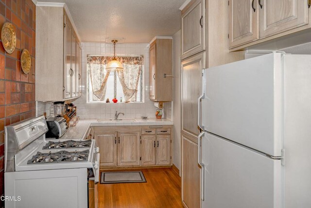 1404 Sycamore Ave, Glendale, CA 91201 - kitchen featuring white appliances, light wood-style floors, backsplash, tile countertops, and hanging light fixtures