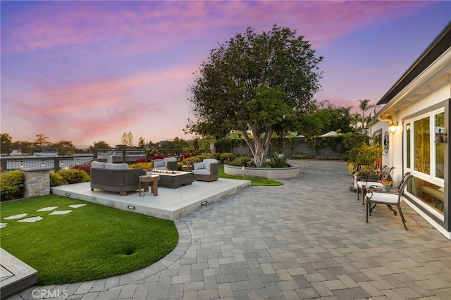 view of patio with a fenced backyard and an outdoor living space with a fire pit