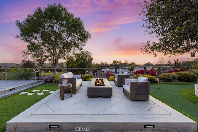 patio terrace at dusk with fence and an outdoor living space with a fire pit