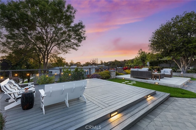 deck at dusk with fence and outdoor lounge area