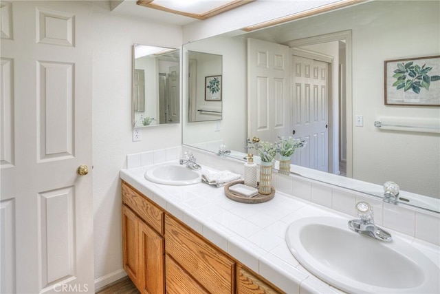 full bathroom with double vanity and a sink