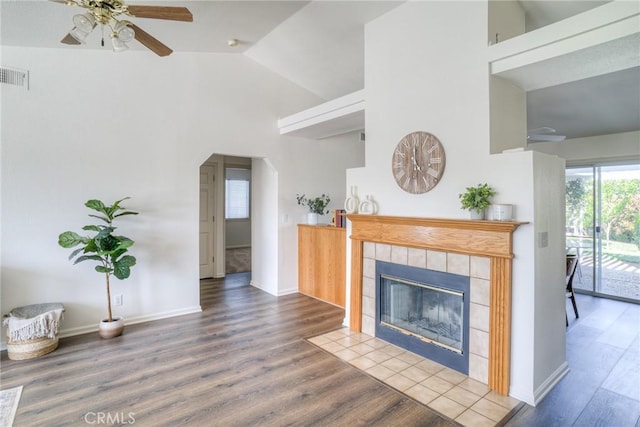 living room with high vaulted ceiling, a ceiling fan, wood finished floors, baseboards, and visible vents