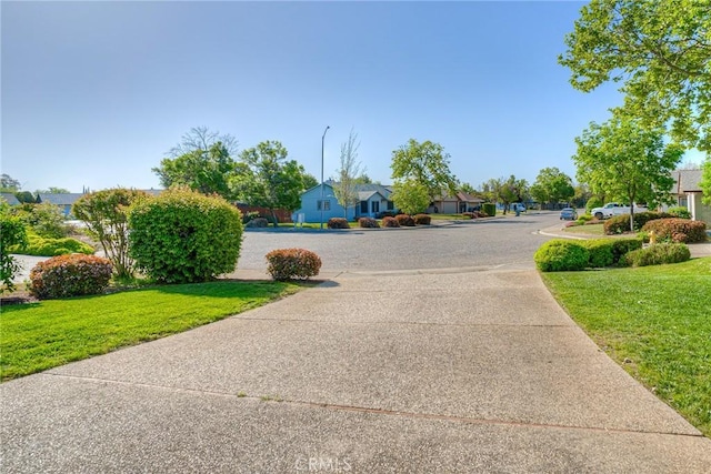 view of street featuring a residential view and concrete driveway