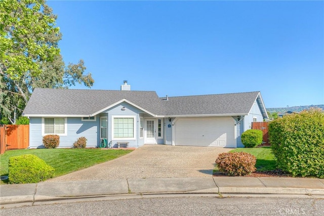 single story home with concrete driveway, an attached garage, fence, and a front yard