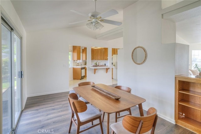 dining area with vaulted ceiling, wood finished floors, baseboards, and ceiling fan